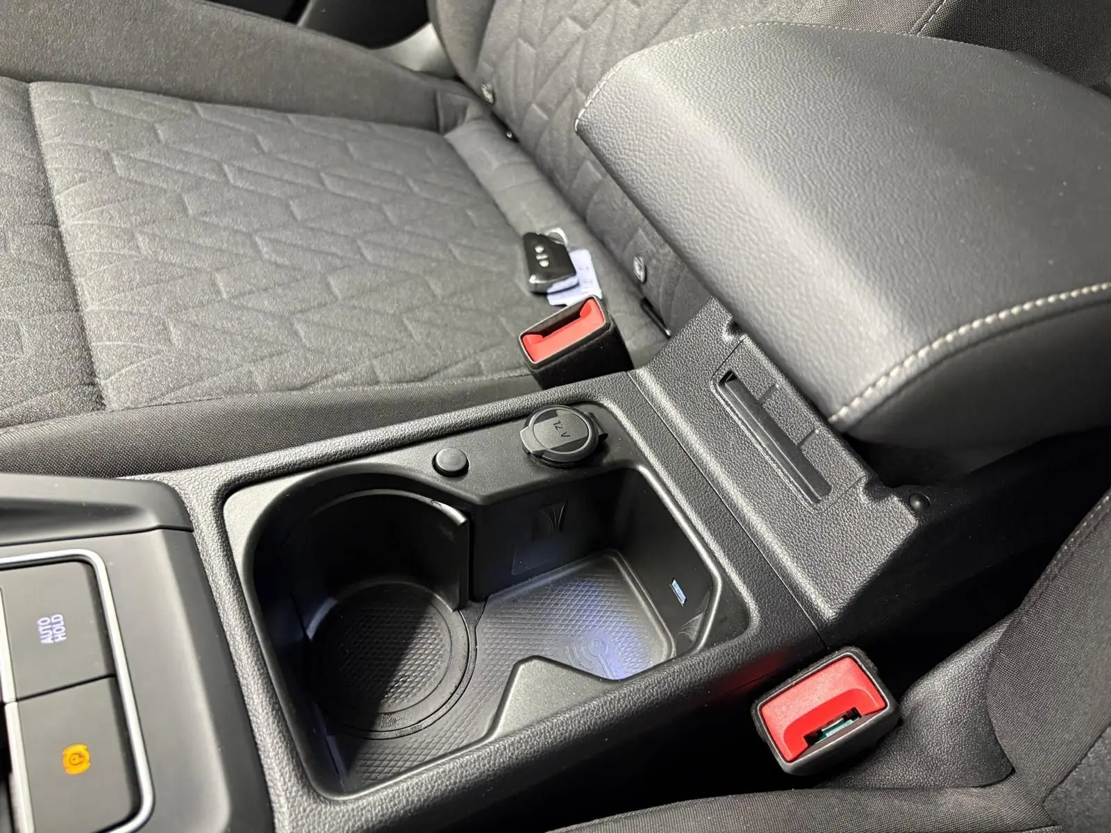 Gros plan sur la console centrale noire et les sièges tissu gris de la Volkswagen Golf 2.0 TDI 2025.