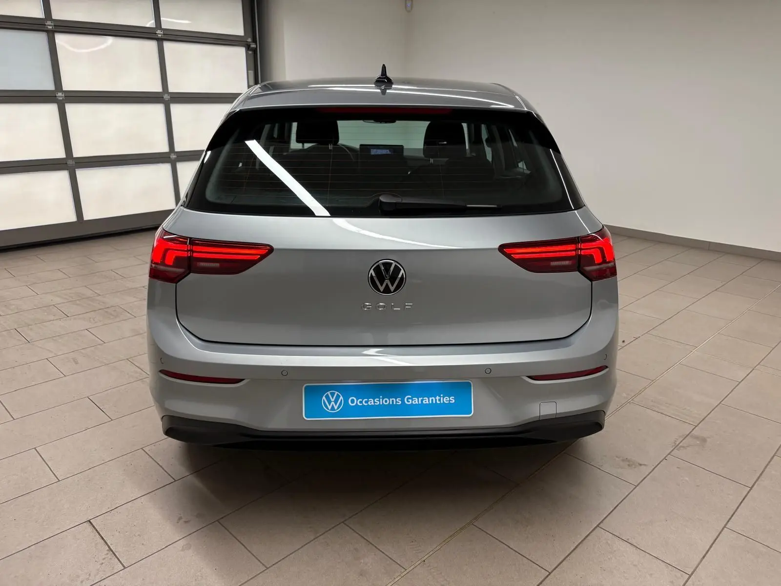Vue arrière d'une Volkswagen Golf 2.0 TDI 116 BVM6 Life Plus 2025 en reflet d'argent, avec feux LED allumés.