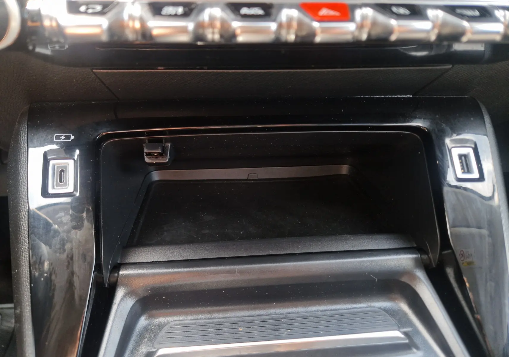 Détail de la console centrale noire du Peugeot 208 1.2 PureTech 110 Allure Pack avec ports USB visibles.
