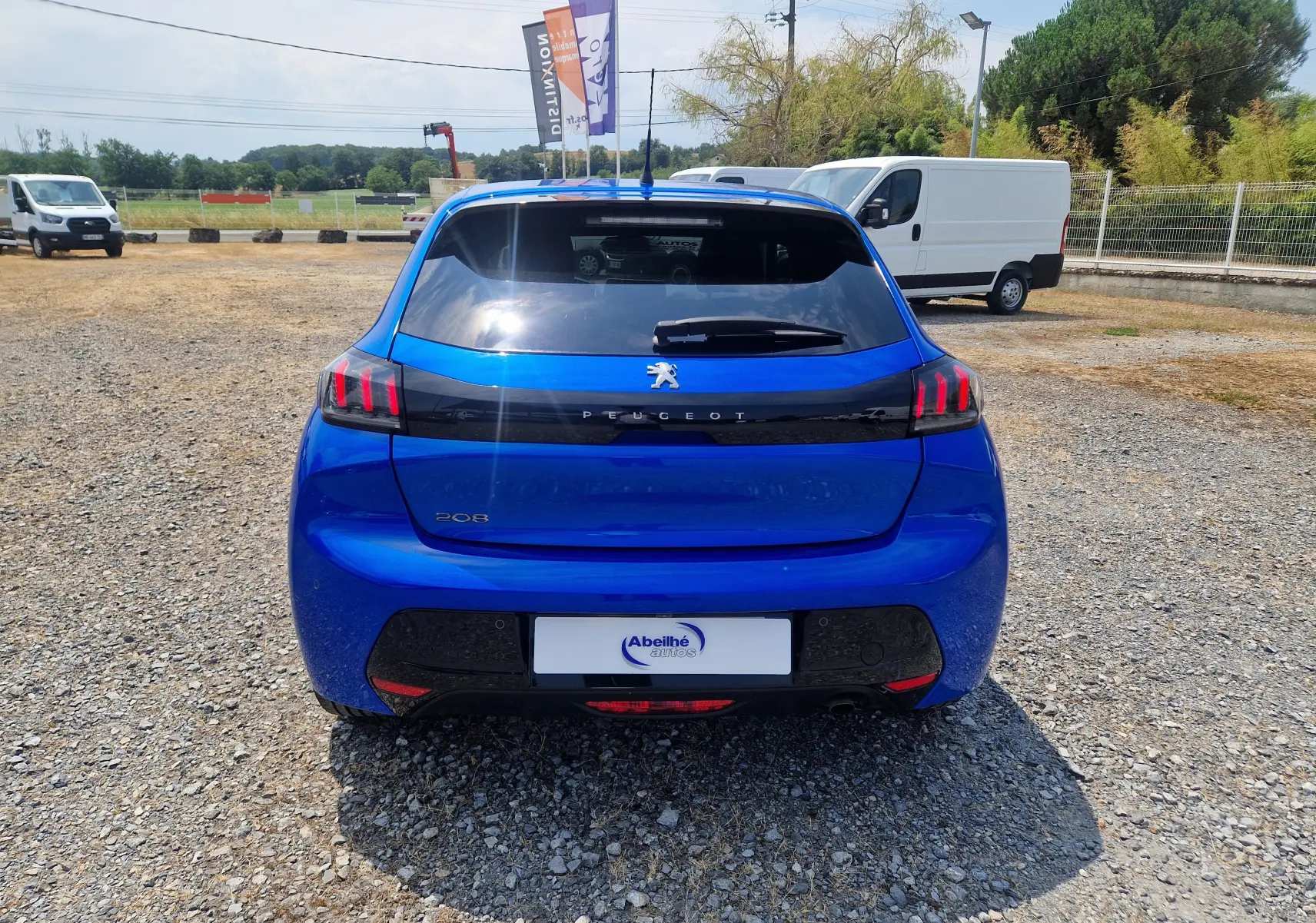 Vue arrière d'une Peugeot 208 1.2 PureTech 110 Allure Pack bleu Vertigo, avec feux arrière à griffes rouges distinctifs.
