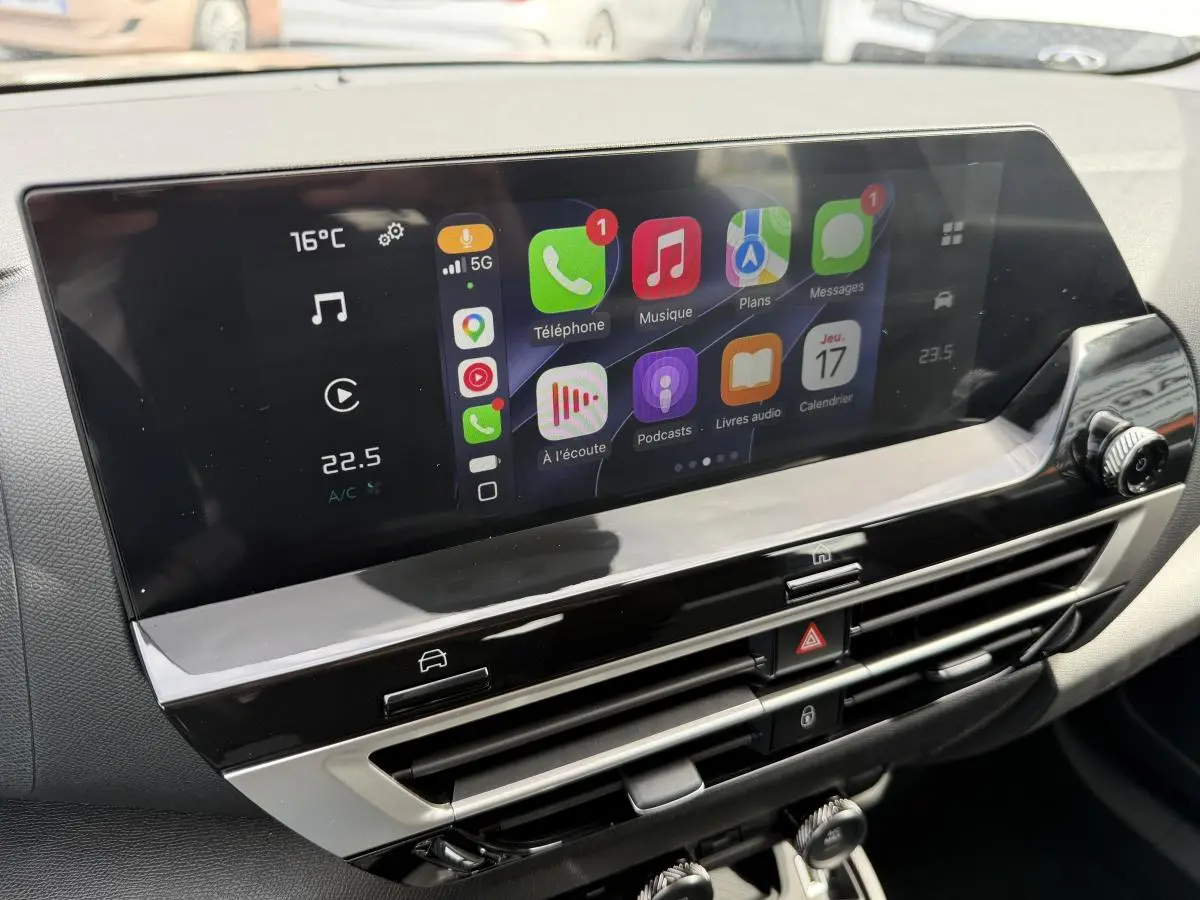 Écran tactile central du tableau de bord de la Citroën C4 ë-136 2025 avec interface Apple CarPlay affichée.