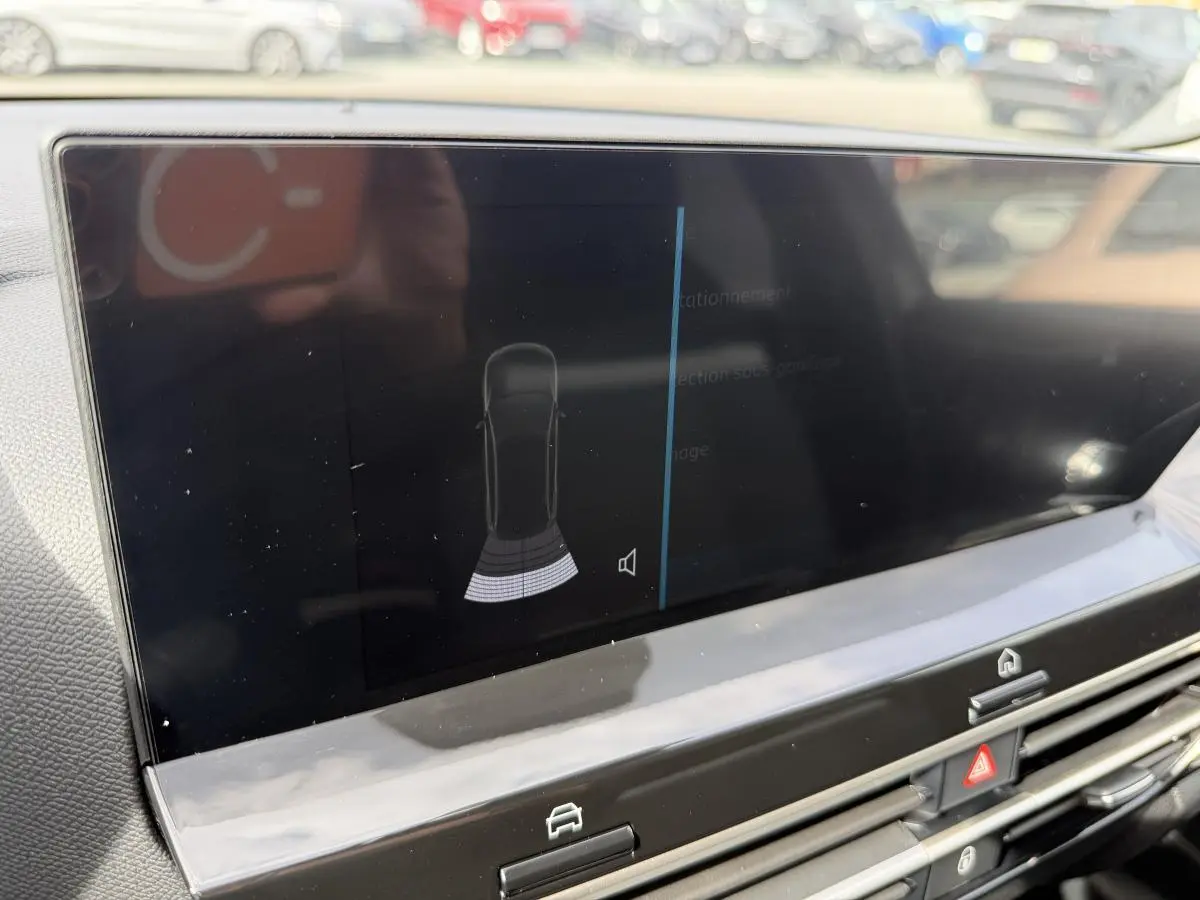 Écran tactile central affichant l'alerte radar arrière dans l'habitacle d'une Citroën C4 ë-136 noir.