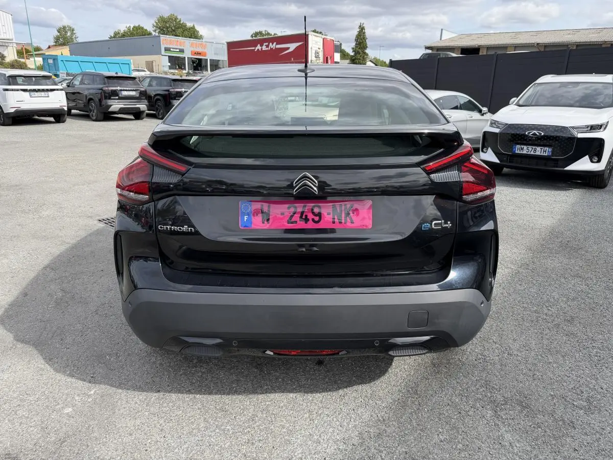 Vue arrière d'une Citroën C4 électrique noire avec inserts noir brillant et feux arrière distinctifs.