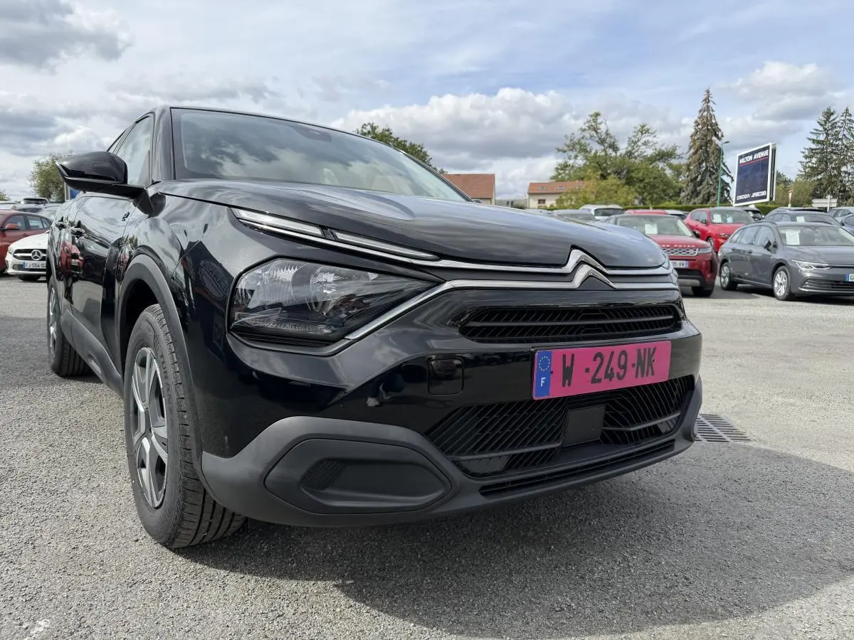 Citroën C4 ë-136 2025 noir, vue 3/4 avant droit, avec inserts noir brillant autour des antibrouillards.