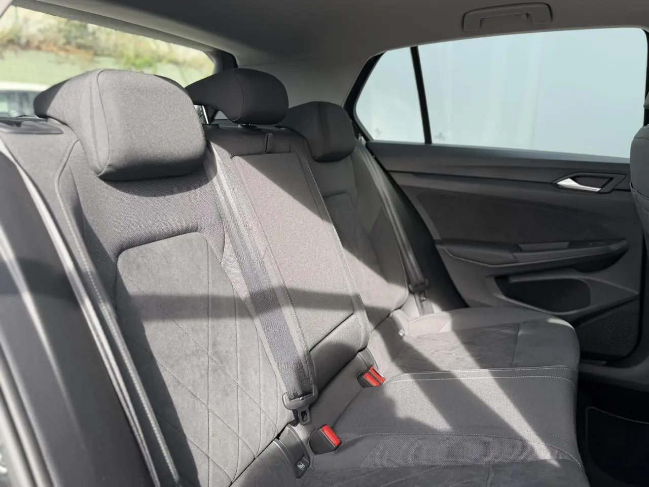 Vue intérieure côté droit des sièges arrière en tissu gris de la Volkswagen Golf VIII 2.0 TSI 2024.