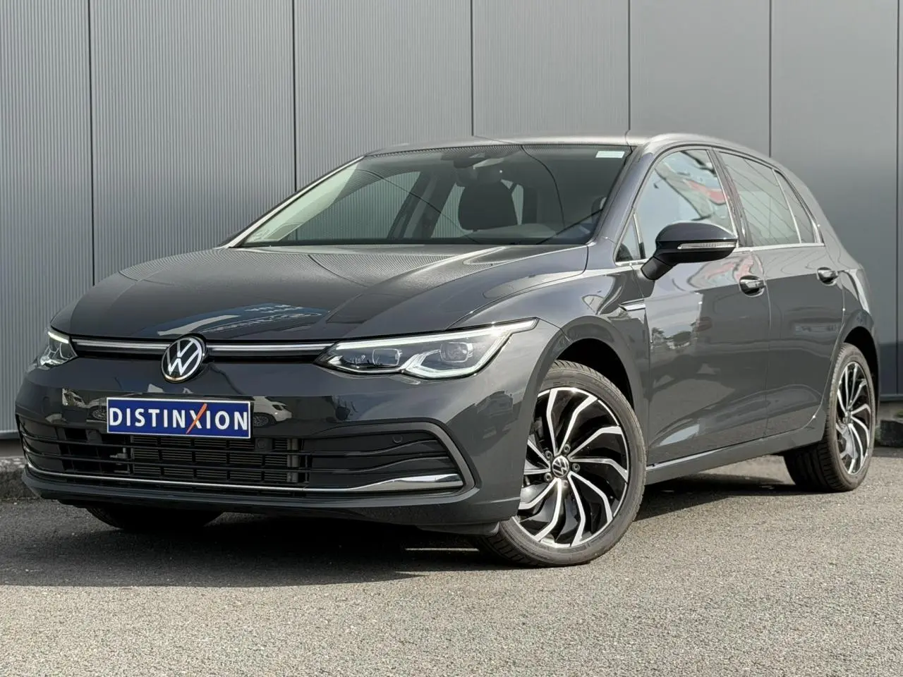 Volkswagen Golf VIII 2.0 TSI gris Urano vue 3/4 avant droit avec jantes alliage distinctives.
