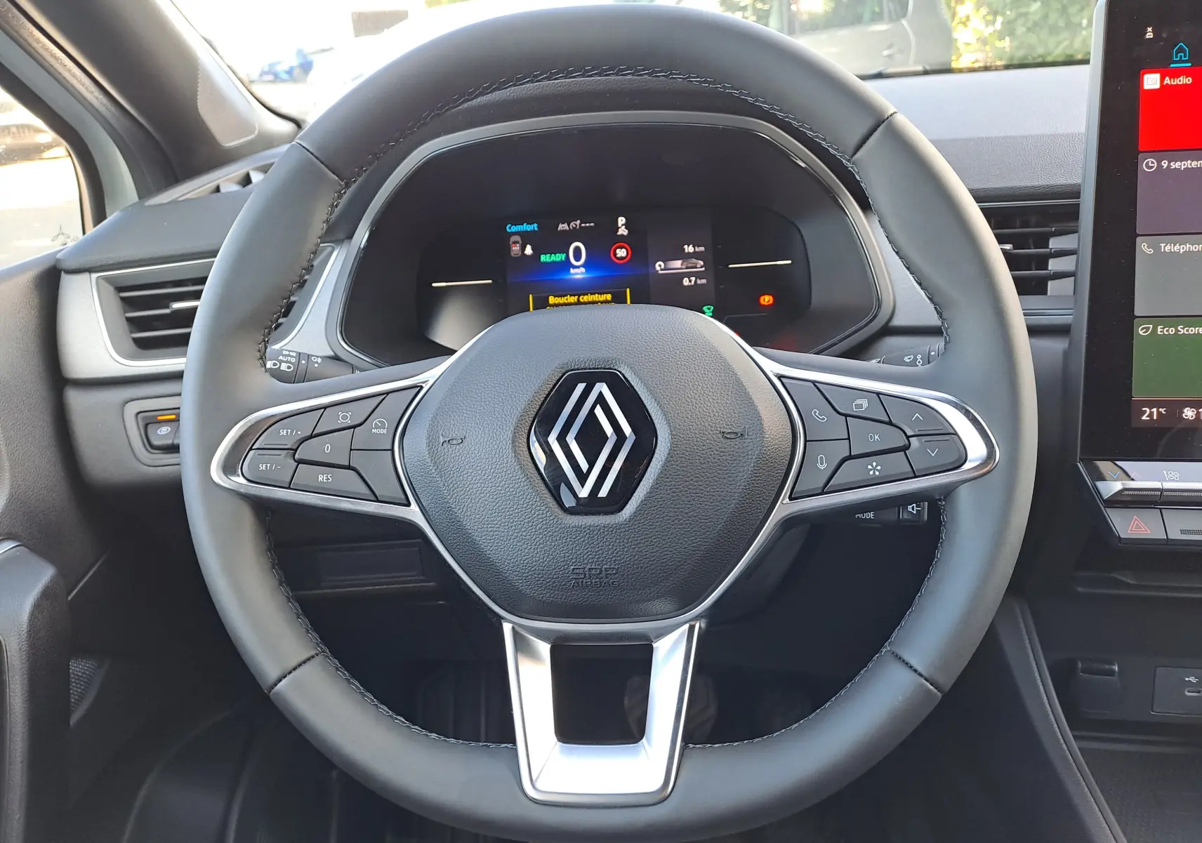 Vue rapprochée du volant noir du Renault Captur 2025 avec commandes intégrées et tableau de bord numérique allumé.