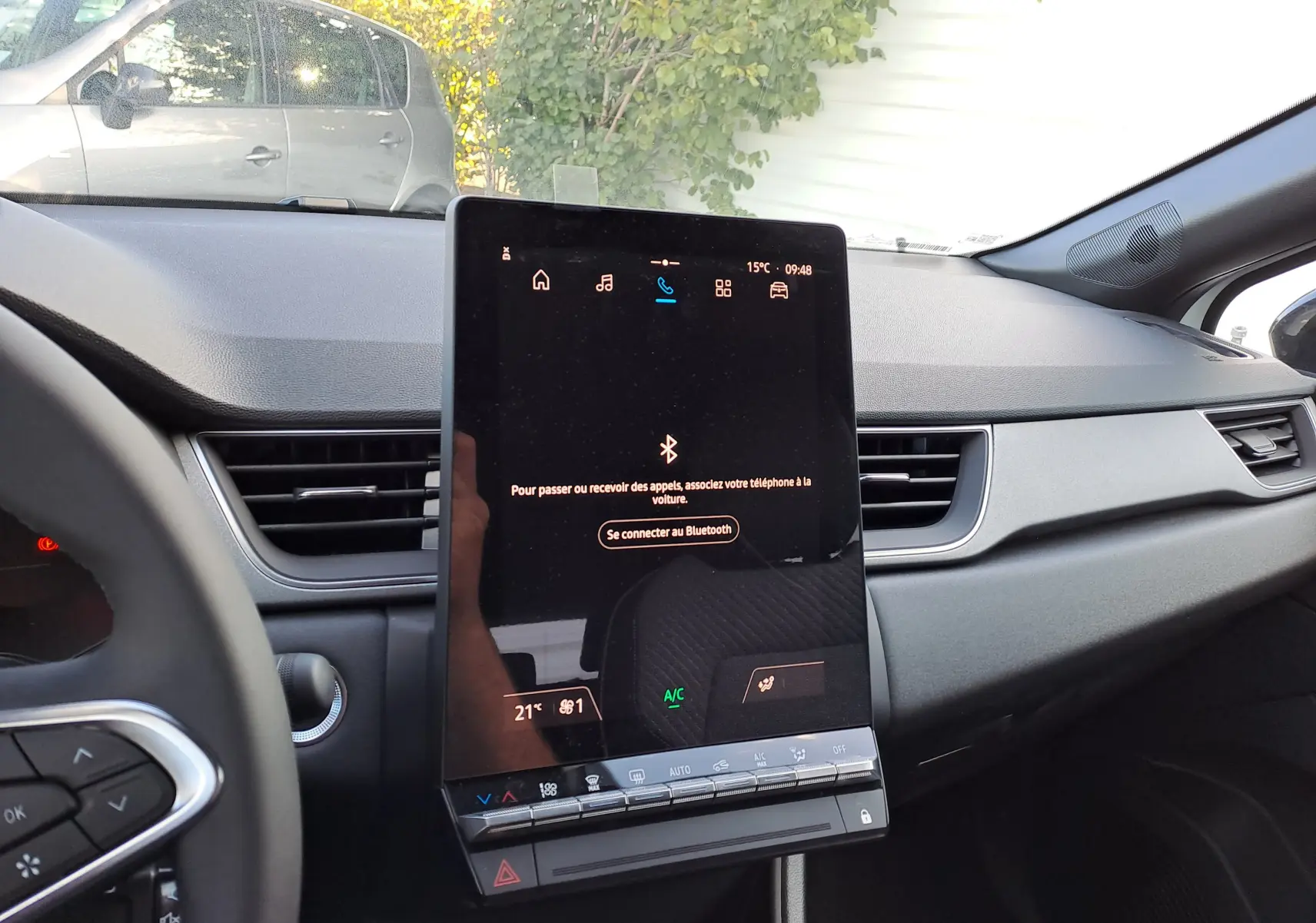 Intérieur du Renault Captur 2025, tableau de bord et écran tactile central en vue frontale, ambiance gris foncé.