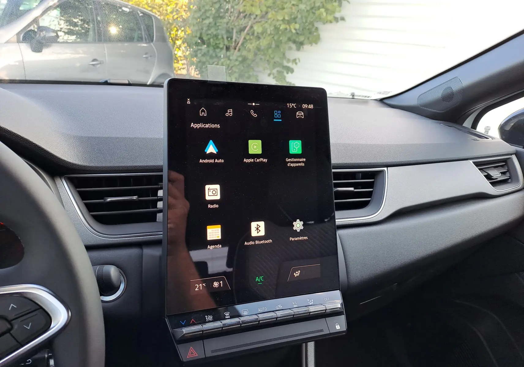 Vue intérieure du tableau de bord du Renault Captur 2025, avec grand écran tactile central et commandes climatisation.