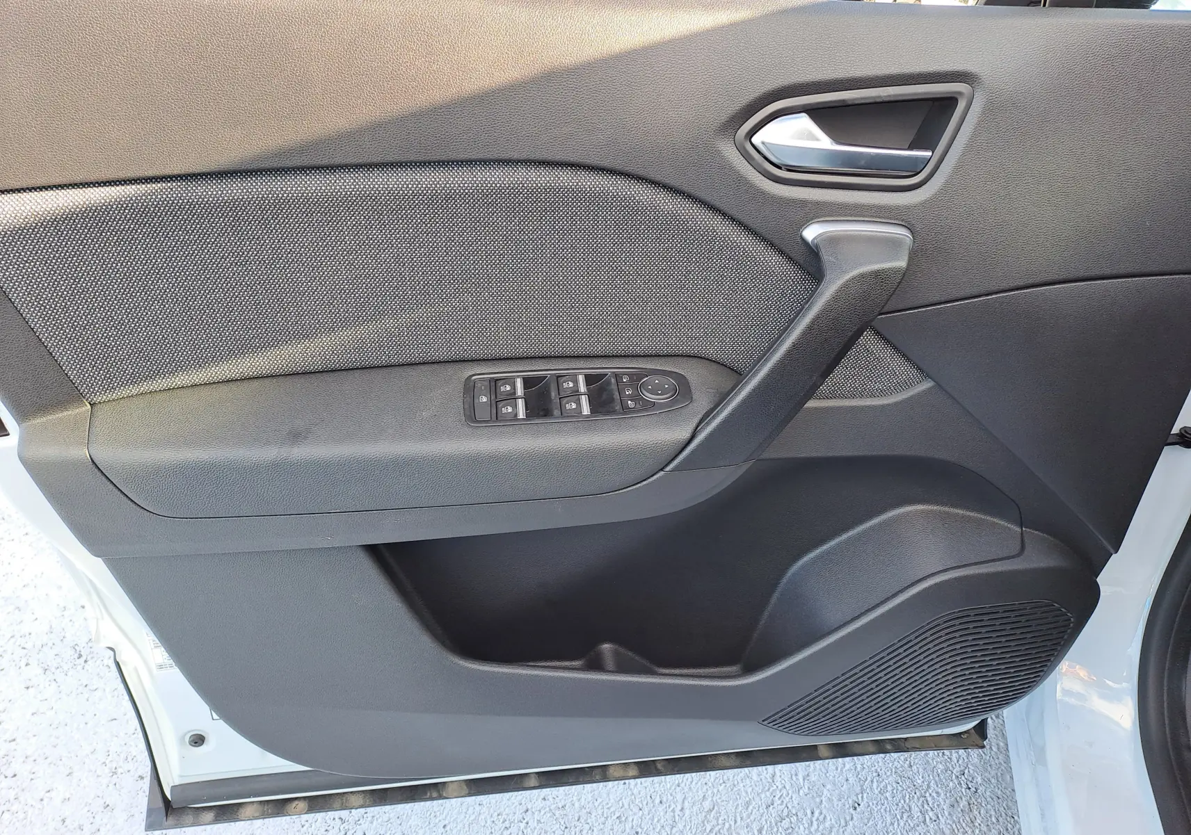 Vue intérieure côté gauche de la porte avant d'un Renault Captur blanc nacré avec commandes électriques des vitres.