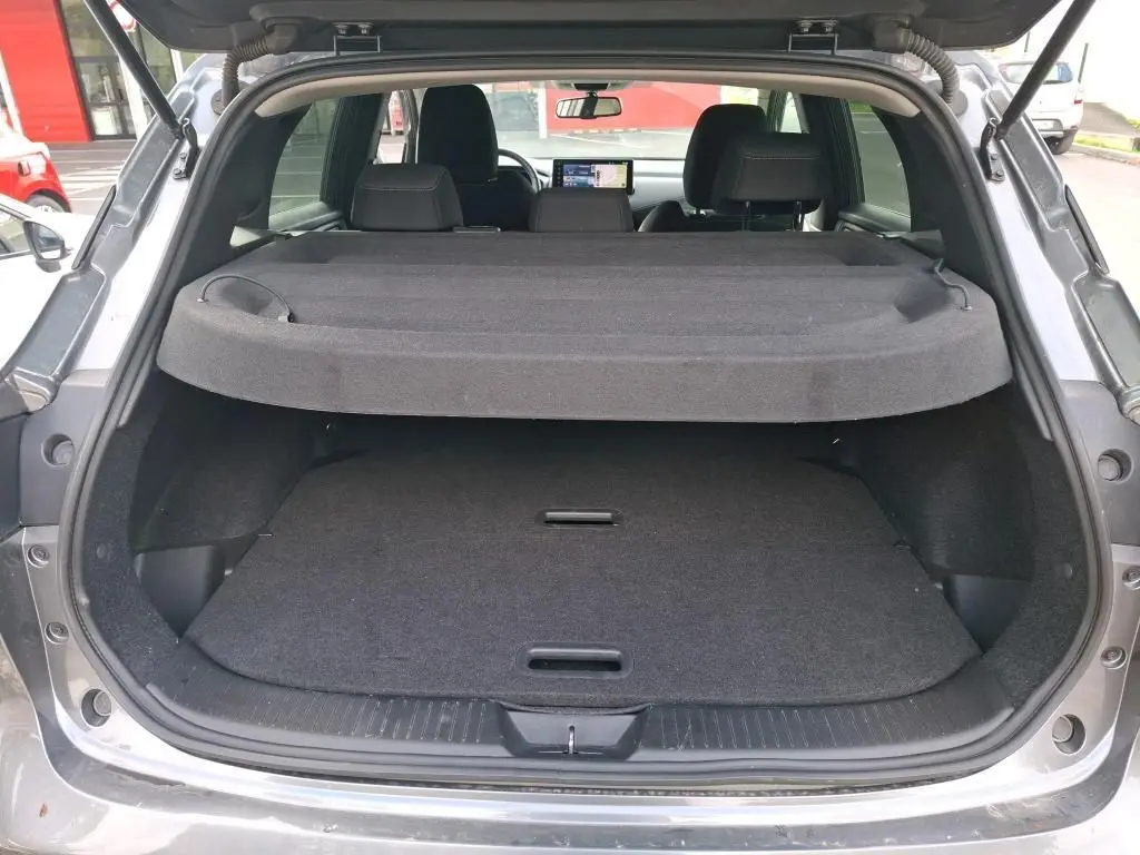 Coffre ouvert vu de l'arrière d'un Nissan Qashqai e-POWER gris foncé 2023 avec cache-bagages en place.