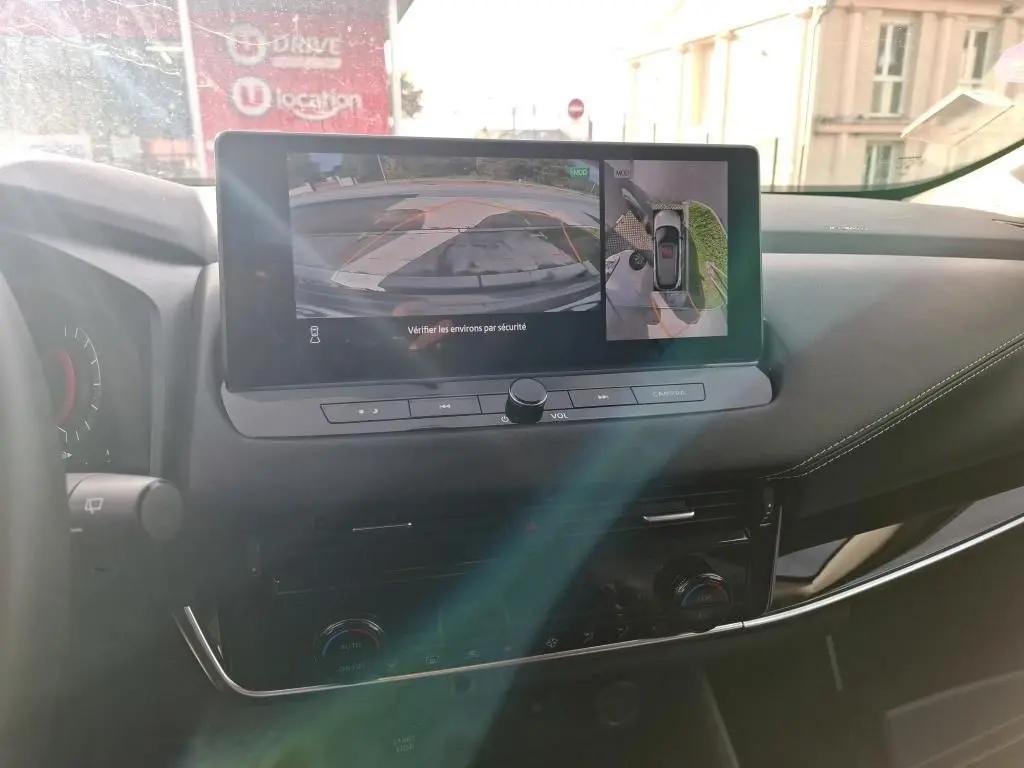 Vue intérieure du tableau de bord du Nissan Qashqai e-POWER 2023 avec écran central affichant la caméra de recul.