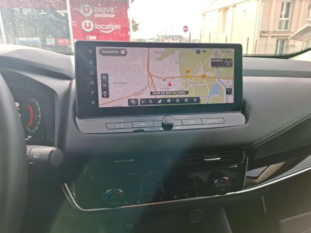 Vue intérieure du tableau de bord du Nissan Qashqai e-POWER 2023 avec écran tactile de navigation et commandes intégrées.