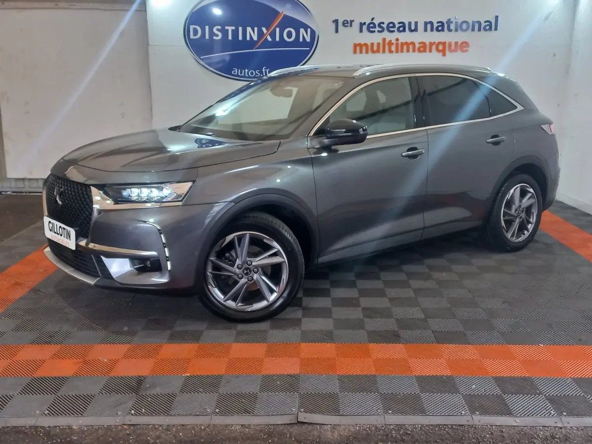 DS7 Crossback gris foncé vu de 3/4 avant droit, avec feux LED allumés et jantes alliage distinctives.