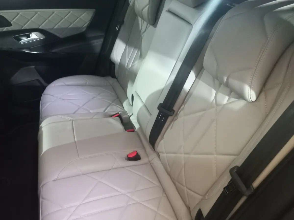 Vue latérale des sièges arrière en cuir beige matelassé du DS7 Crossback, avec ceinture de sécurité noire visible.