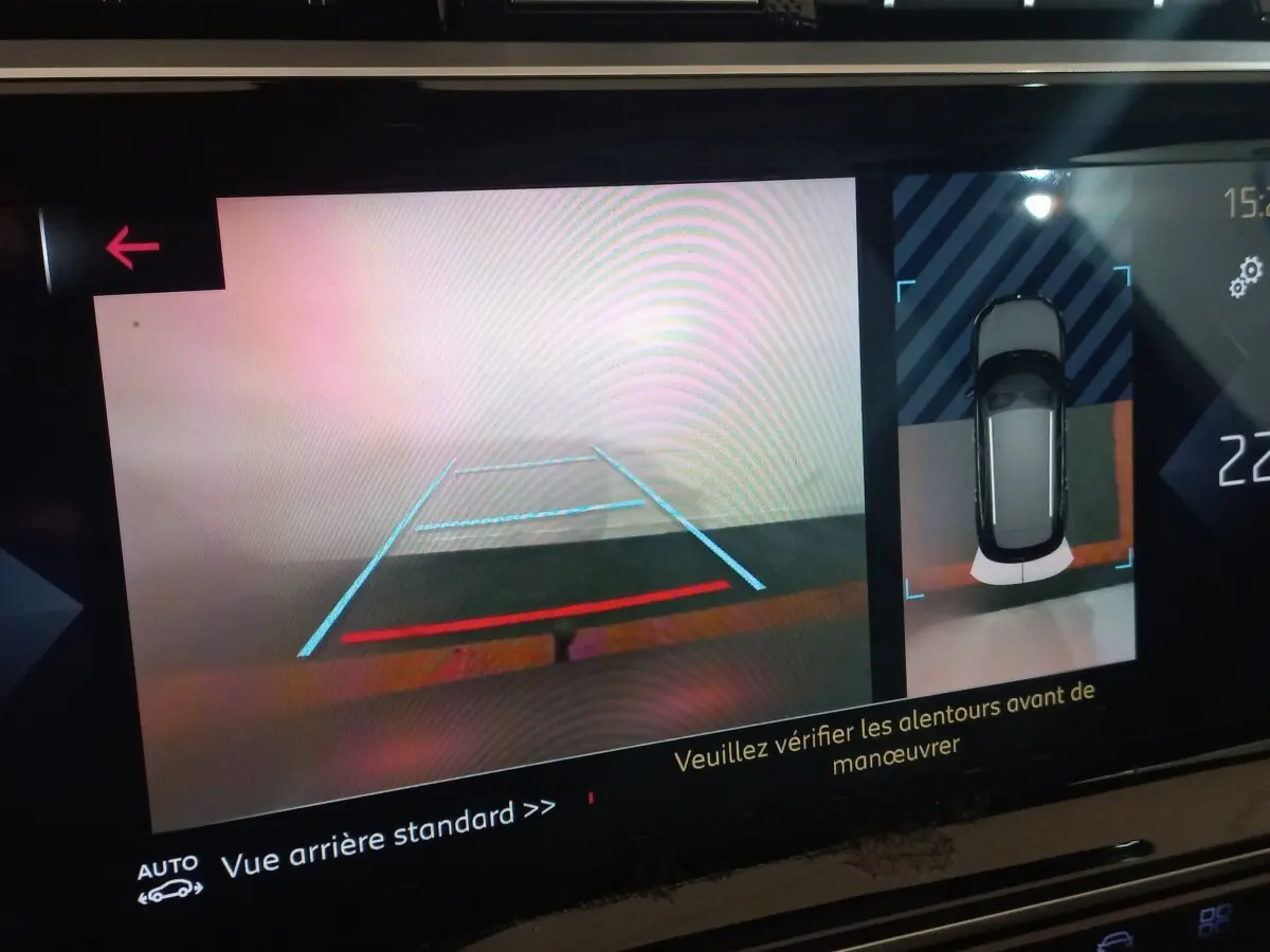 Écran tactile affichant la caméra de recul et vue aérienne du DS7 Crossback gris foncé en marche arrière.