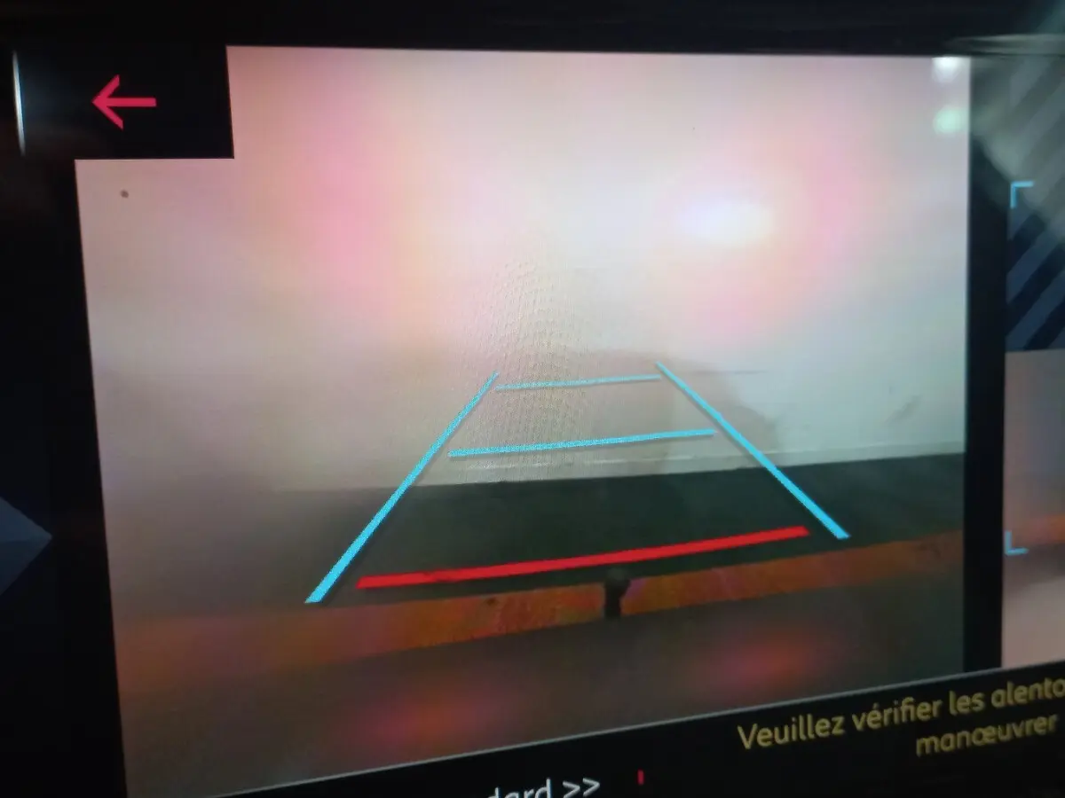Vue caméra de recul du DS7 Crossback gris foncé, affichant les lignes de guidage bleues et rouges sur écran tactile.
