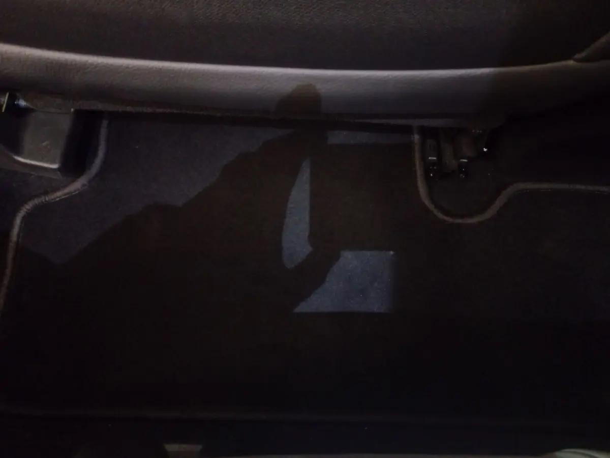 Vue du sol côté passager arrière du DS7 Crossback gris foncé, montrant la moquette et les fixations de siège.