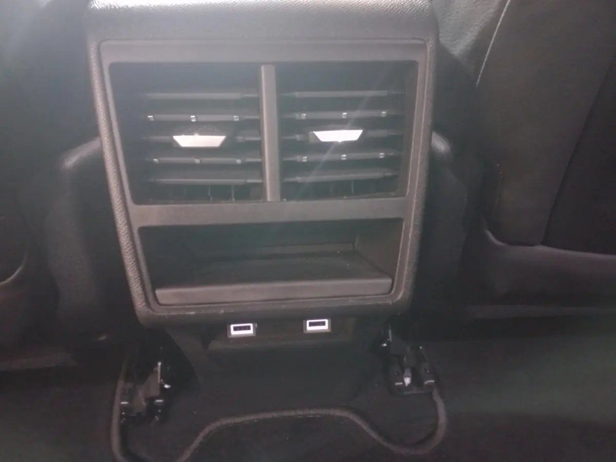 Vue rapprochée des aérateurs arrière et des deux ports USB noirs dans l’habitacle du DS7 Crossback gris foncé.