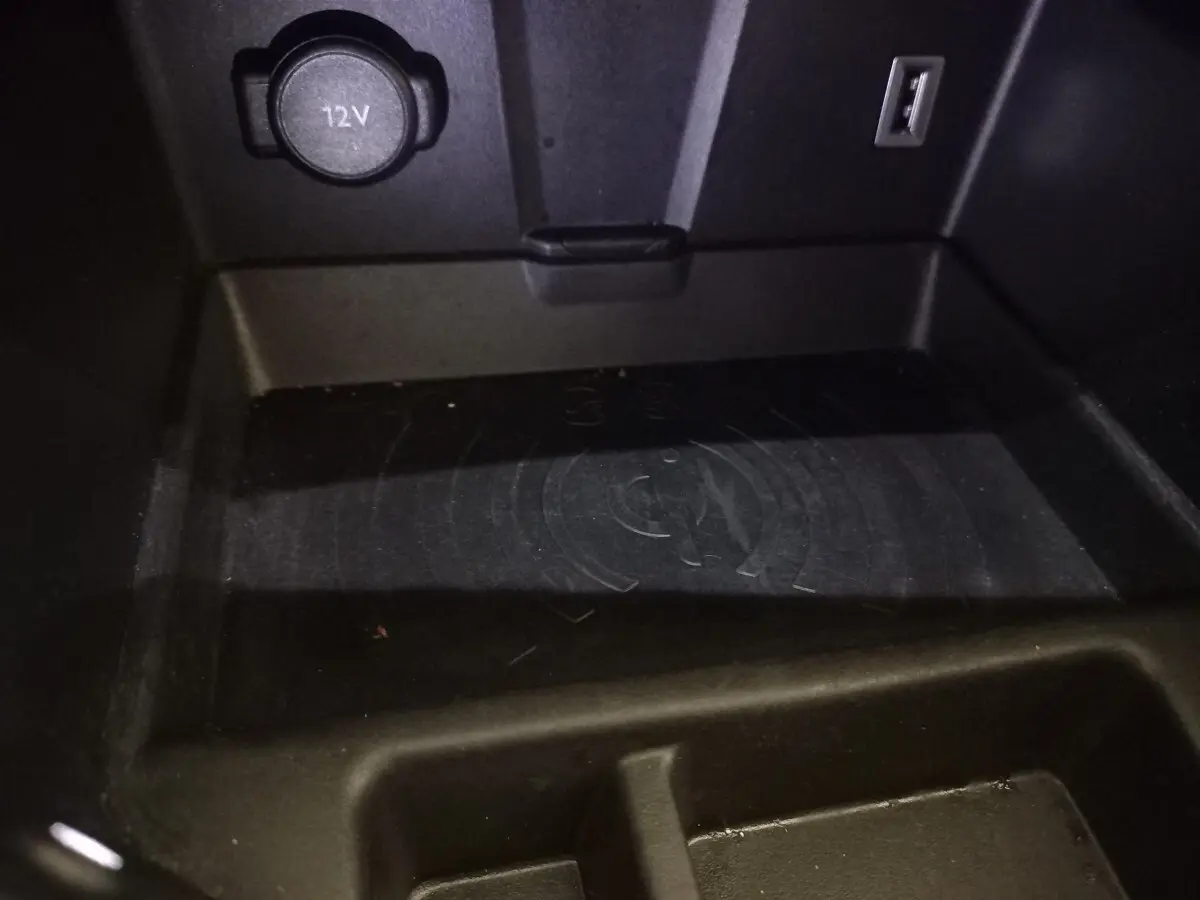 Gros plan sur la zone de recharge par induction et prise 12V du DS7 Crossback gris foncé, intérieur console centrale.
