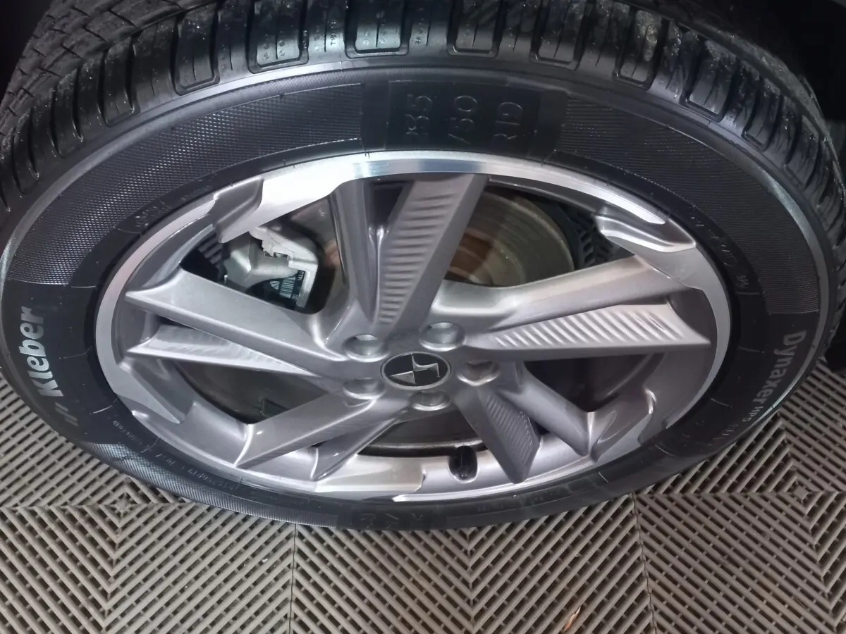 Gros plan sur la jante alliage argentée et le pneu Kleber Dynaxer HP3 du DS7 Crossback gris foncé.