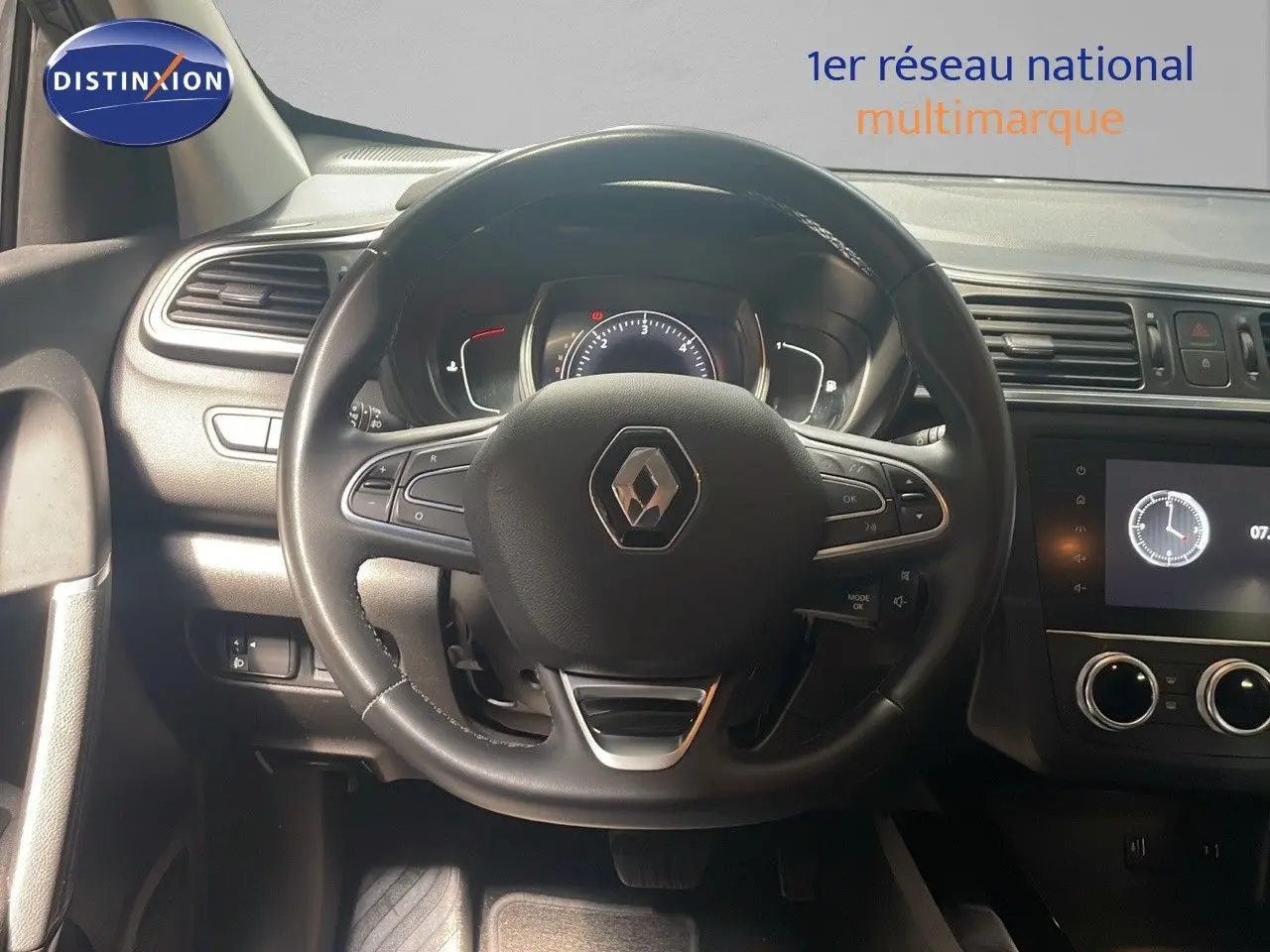 Vue intérieure centrée sur le volant Renault du Kadjar 2021 avec tableau de bord et écran tactile allumé.
