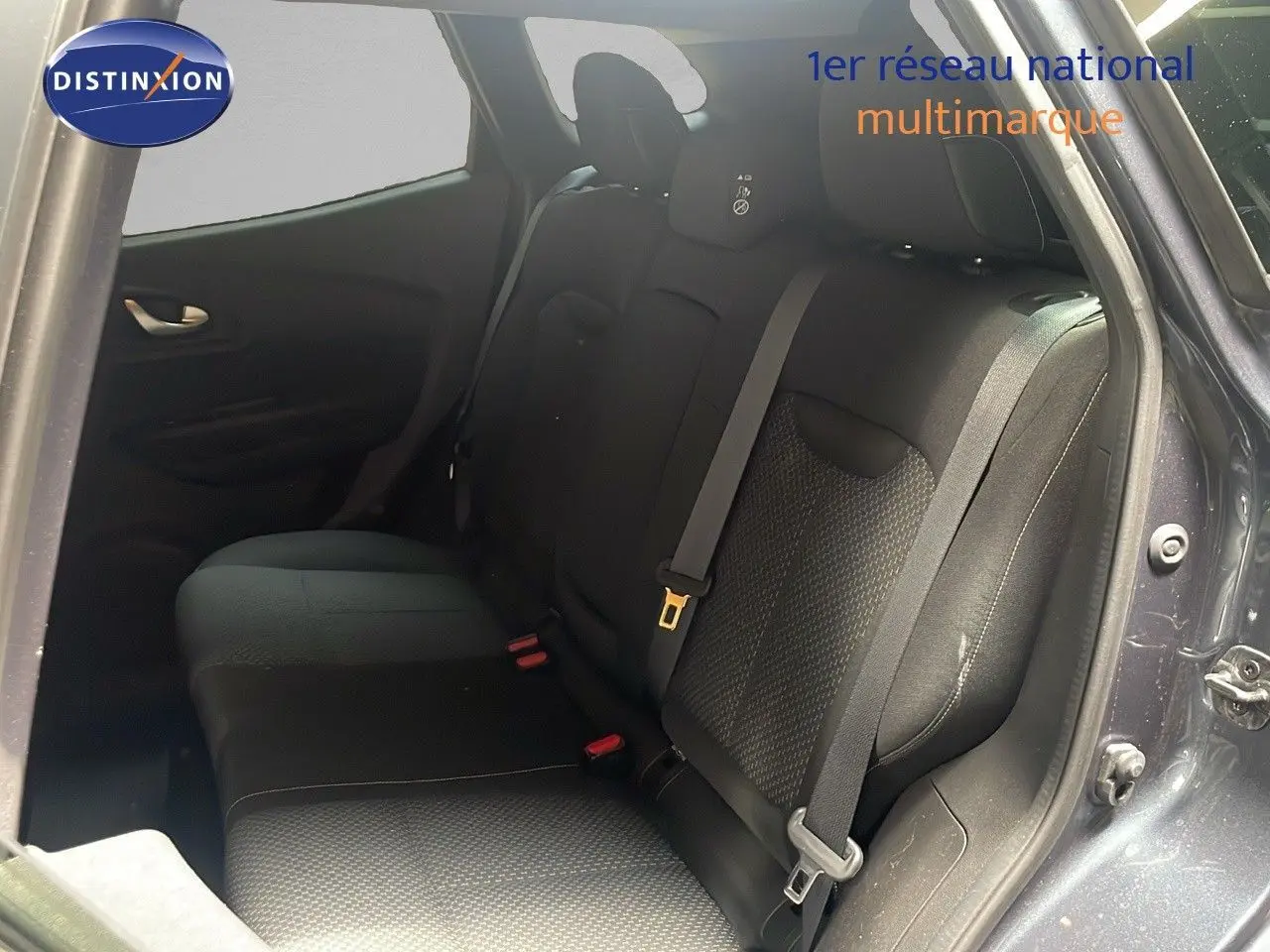 Vue intérieure arrière droite du Renault Kadjar gris titanium, montrant la banquette arrière en tissu noir avec ceinture de sécurité.