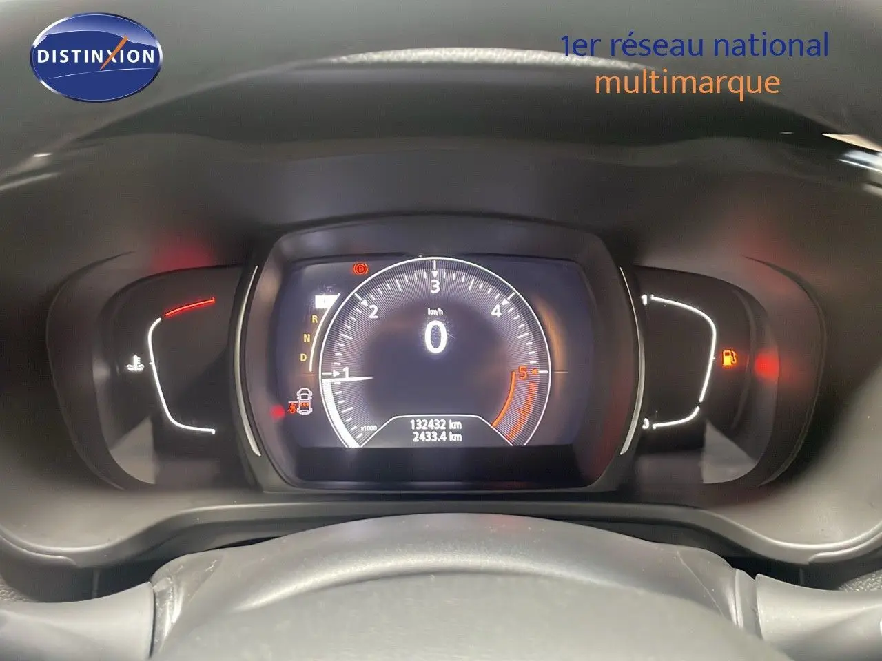 Vue rapprochée du tableau de bord numérique du Renault Kadjar gris titanium, affichant le compteur et les voyants allumés.