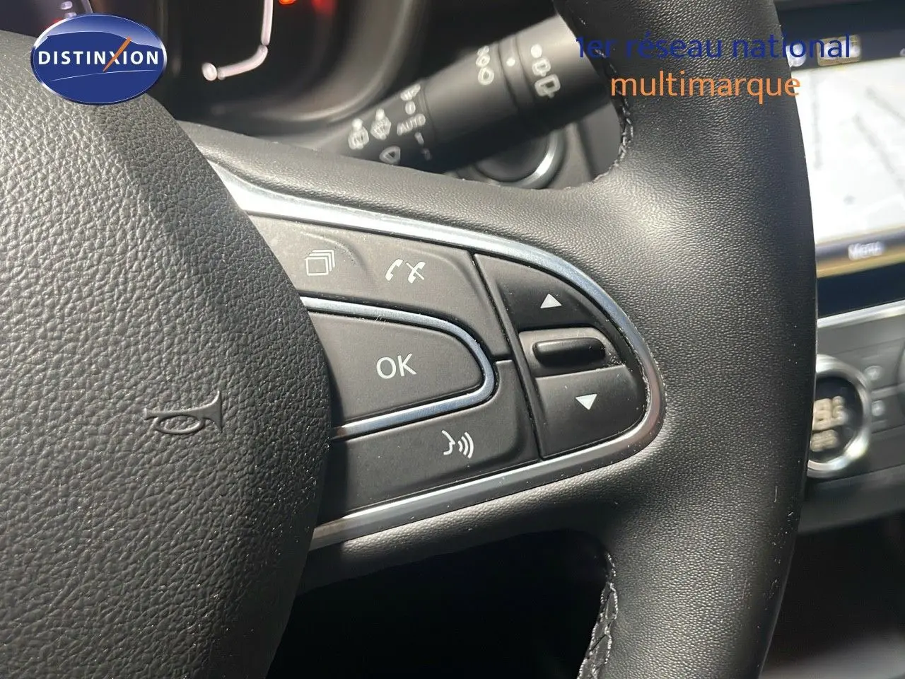 Gros plan sur les commandes au volant du Renault Kadjar gris titanium, avec affichage partiel de l’écran tactile et tableau de bord.