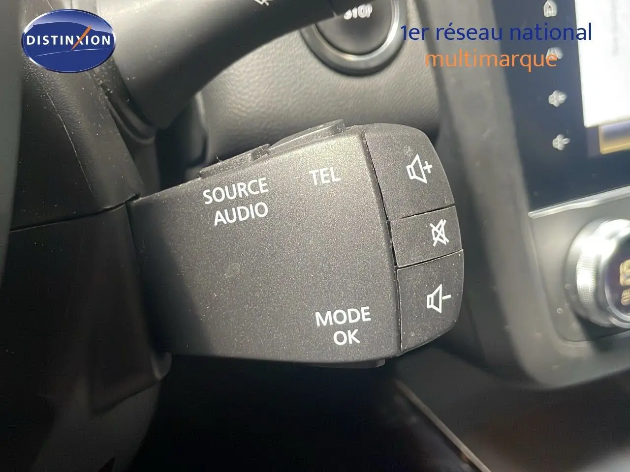 Gros plan sur la commande audio au volant du Renault Kadjar gris titanium, avec boutons source, téléphone et volume.