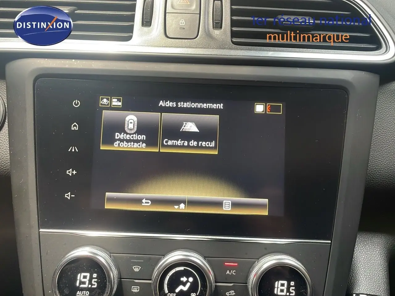 Écran tactile central du Renault Kadjar gris titanium montrant les aides au stationnement avec détection d'obstacle et caméra de recul.