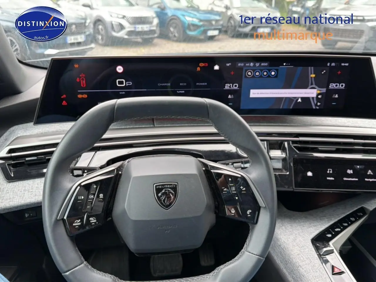 Vue intérieure centrée sur le volant cuir multifonction et les écrans numériques du Peugeot 3008 gris titane 2025.