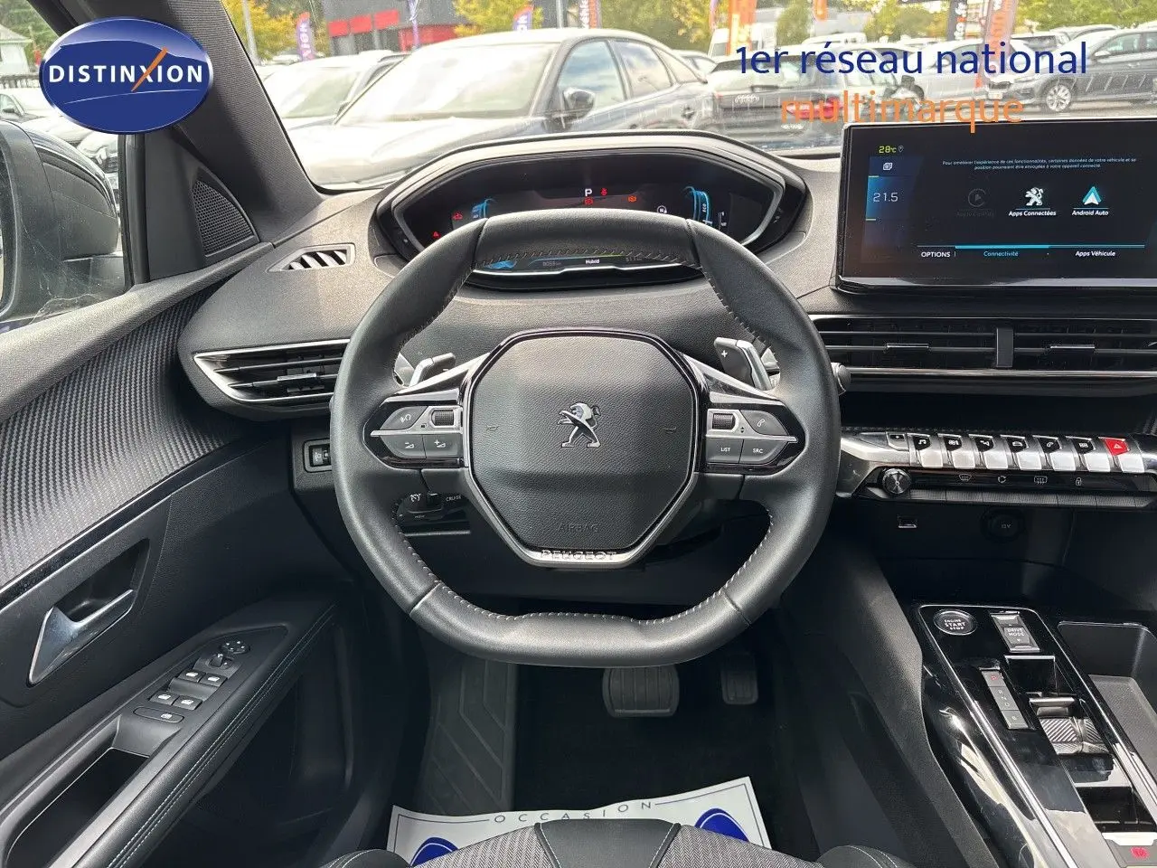 Vue intérieure centrée sur le volant cuir noir du Peugeot 3008 Hybrid 2024, avec tableau de bord digital et écran tactile.