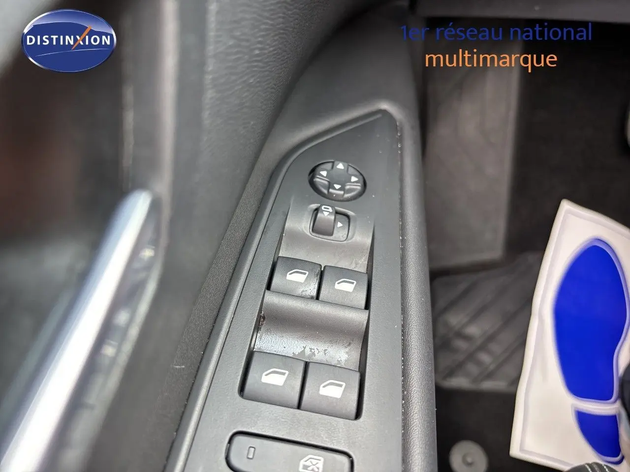 Gros plan sur les commandes des vitres et rétroviseurs côté conducteur d’un Peugeot 3008 noir métal 2024.