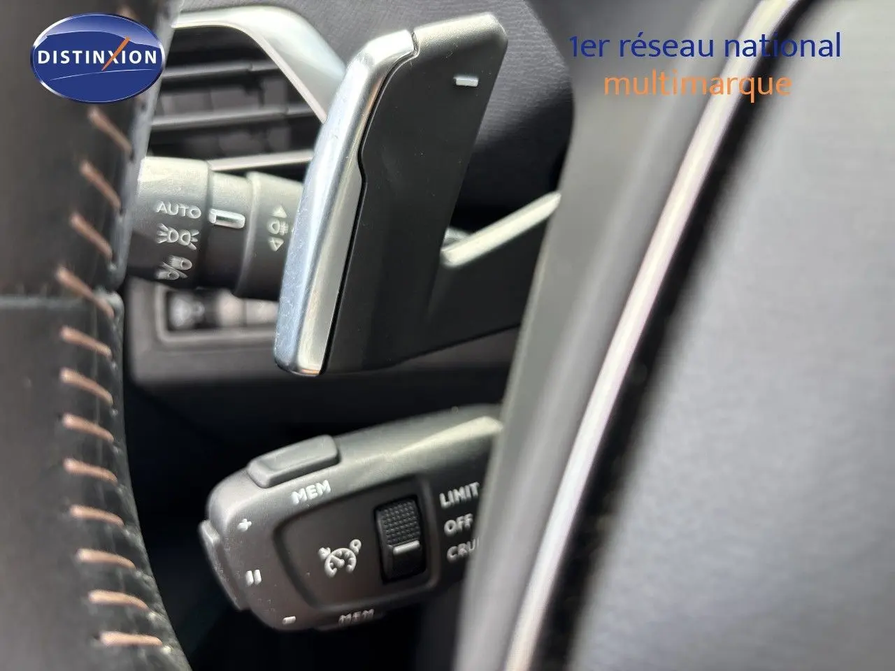 Gros plan sur la commande de régulateur de vitesse au volant d’un Peugeot 3008 noir métal 2024 hybride rechargeable.