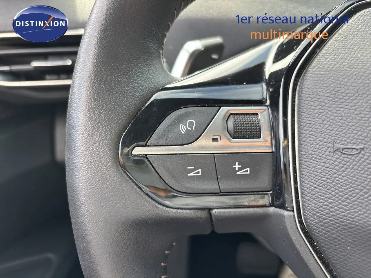 Gros plan sur les commandes du volant côté gauche du Peugeot 3008 noir métal hybride rechargeable 2024.
