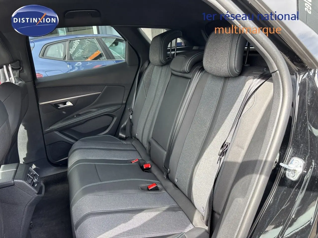 Vue intérieure arrière côté droit du Peugeot 3008 Hybrid 180ch Allure 2024 noir métal, montrant les sièges arrière en tissu et cuir.