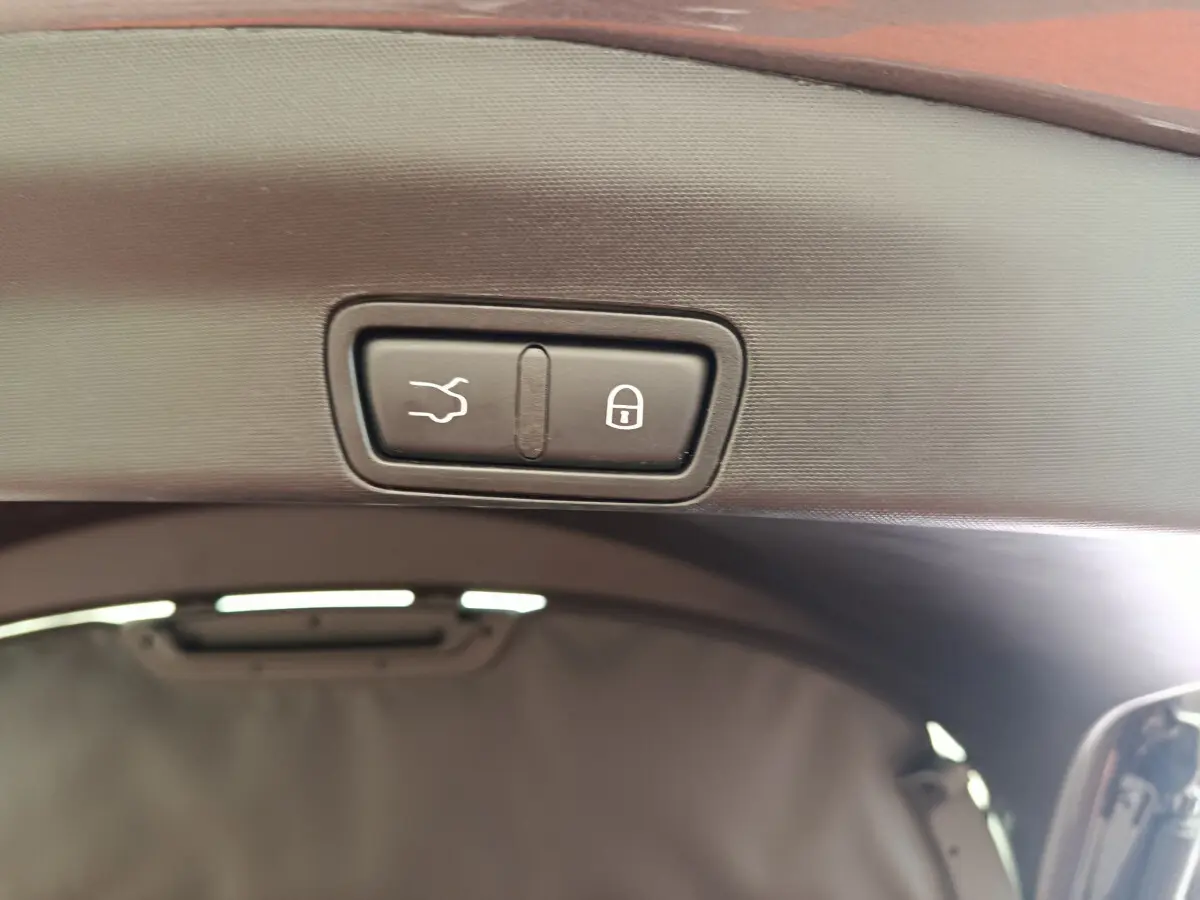 Gros plan sur les boutons d’ouverture et de verrouillage électrique du coffre d’un Alfa Romeo Stelvio gris foncé.