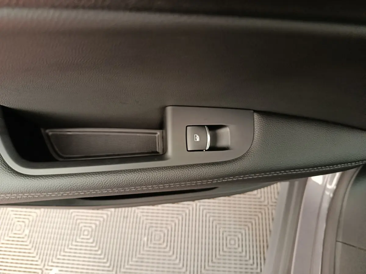 Vue rapprochée de la porte côté gauche d’un Alfa Romeo Stelvio gris foncé, avec bouton de verrouillage centralisé.