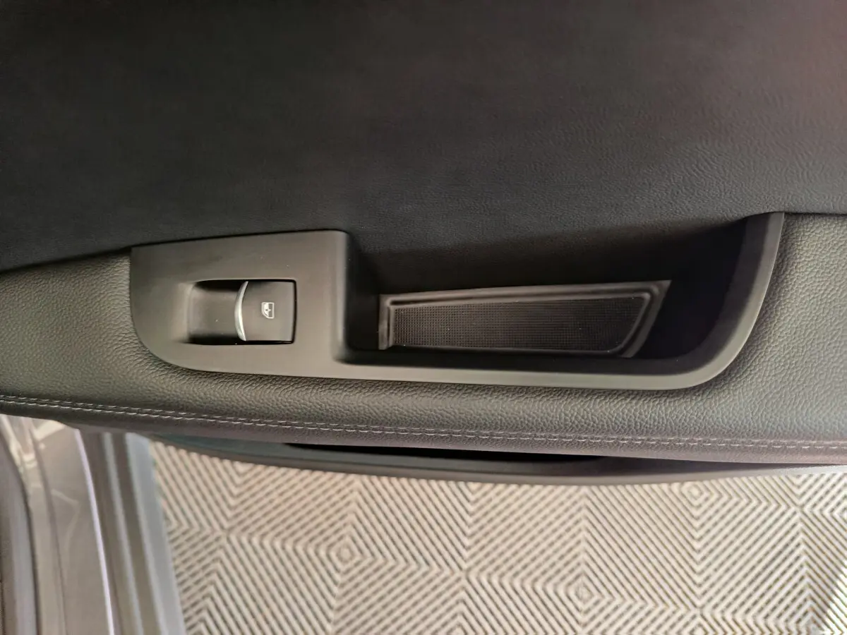 Détail de la commande de lève-vitre côté gauche sur la porte intérieure grise de l'Alfa Romeo Stelvio 2024.