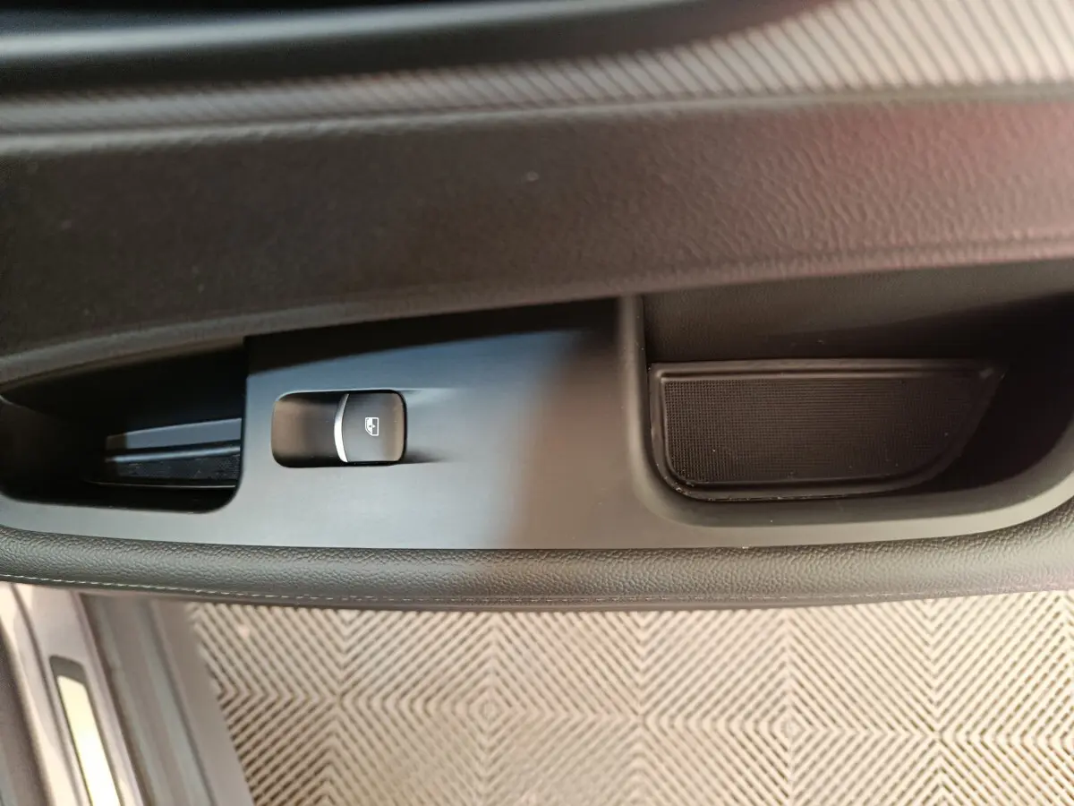 Gros plan sur la commande de lève-vitre côté gauche de l'Alfa Romeo Stelvio gris foncé 2024, intérieur noir.
