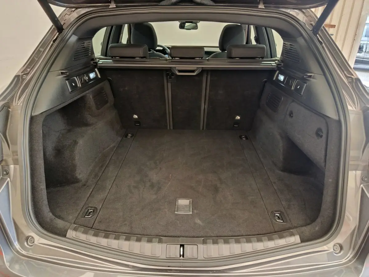 Coffre ouvert vu de l'arrière d'un Alfa Romeo Stelvio gris foncé, montrant un espace de chargement propre et spacieux.