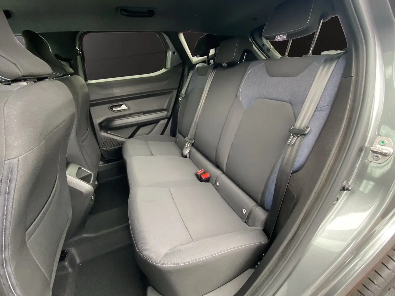 Vue intérieure côté droit sur la banquette arrière noire et bleu du Dacia Duster Gris Schiste 2025 hybride.