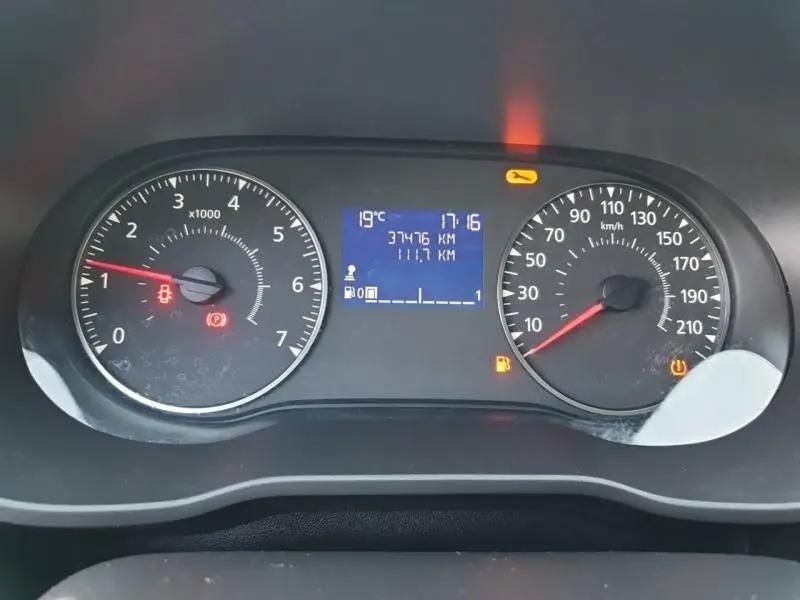 Tableau de bord du Dacia Duster blanc 2021 montrant compte-tours, vitesse, et écran digital avec alertes allumées.