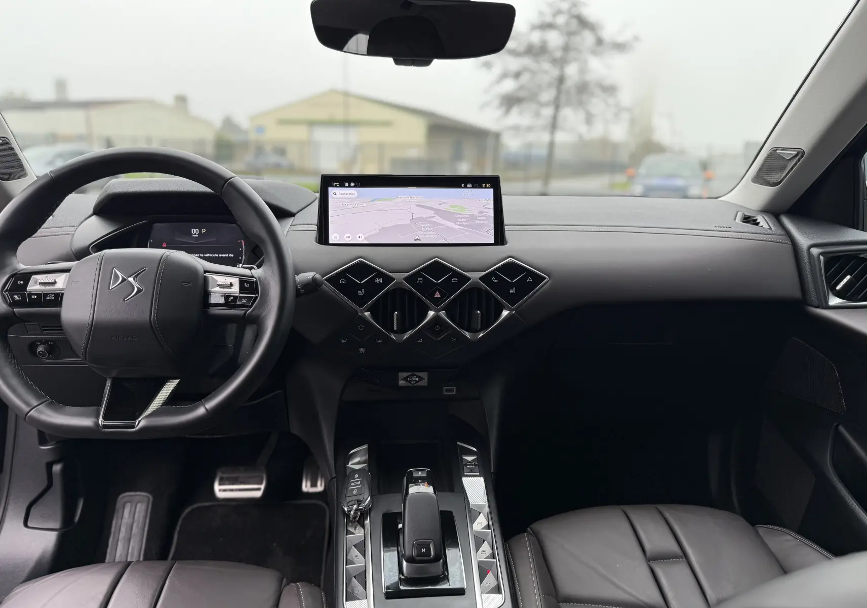 Intérieur du DS3 BlueHDi 130 2024 en cuir noir, vue frontale du tableau de bord avec écran tactile et volant multifonction.