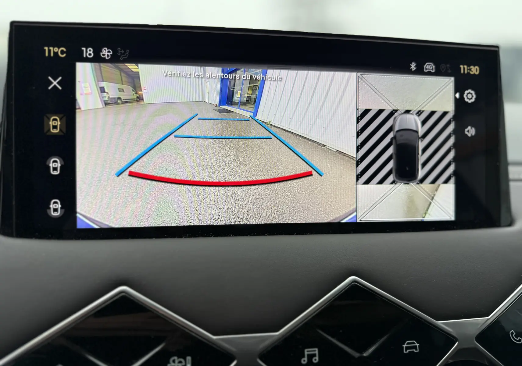 Écran de caméra de recul et vue 360 du DS3 noir Perla Nera, affichant les lignes de guidage en bleu et rouge.