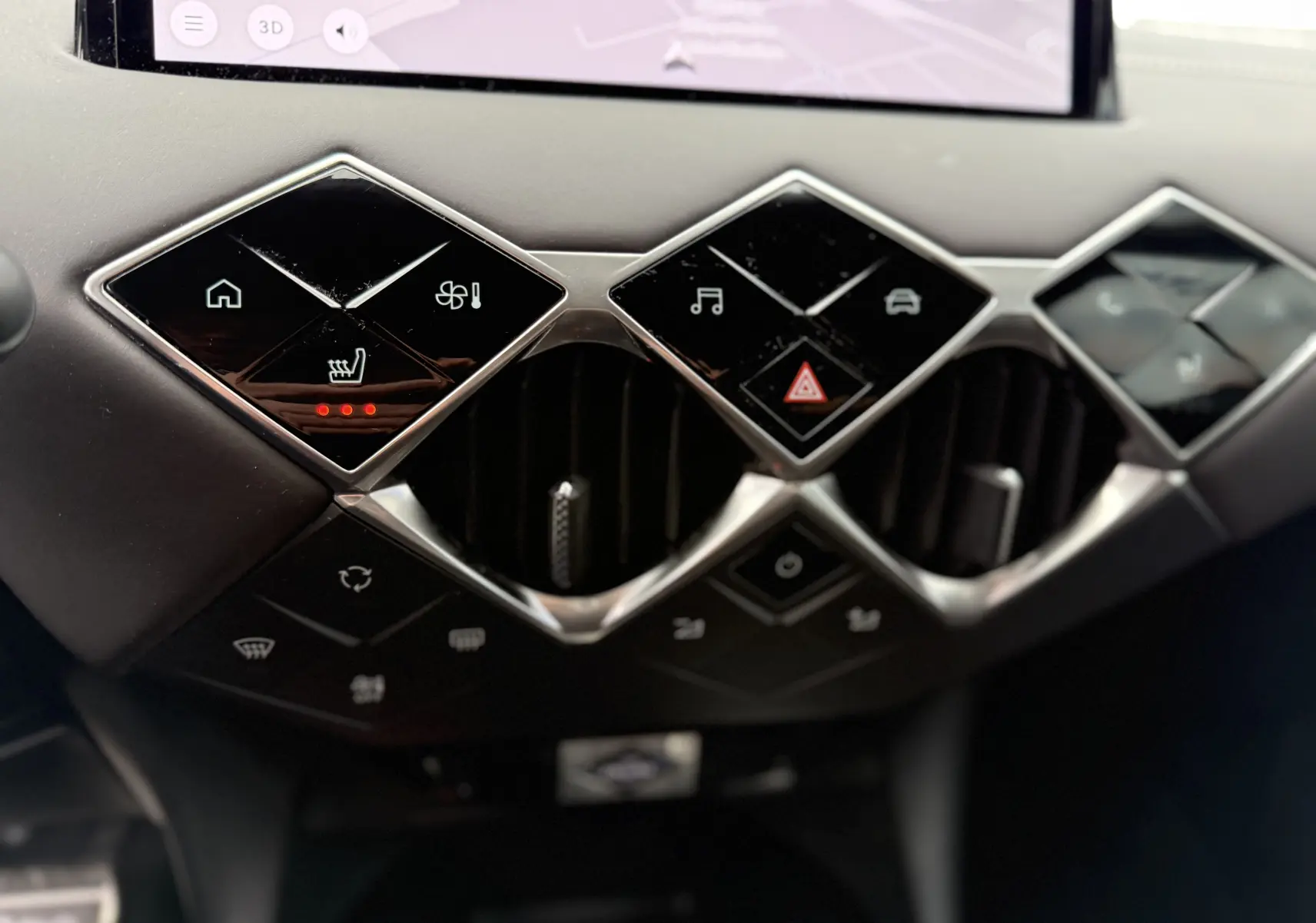 Détail du tableau de bord du DS3 2024 noir Perla Nera montrant les commandes tactiles en losange et les aérateurs centraux.