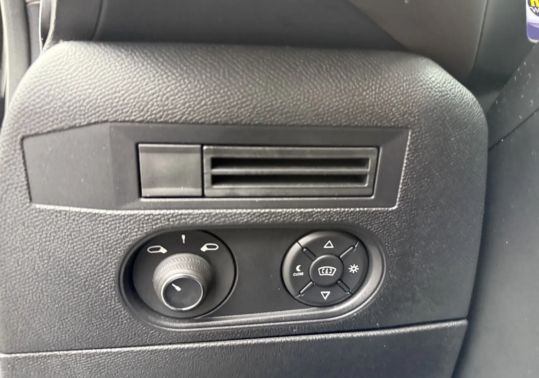 Vue rapprochée des commandes de réglage des rétroviseurs et de la ventilation intérieure du DS3 noir Perla Nera 2024.