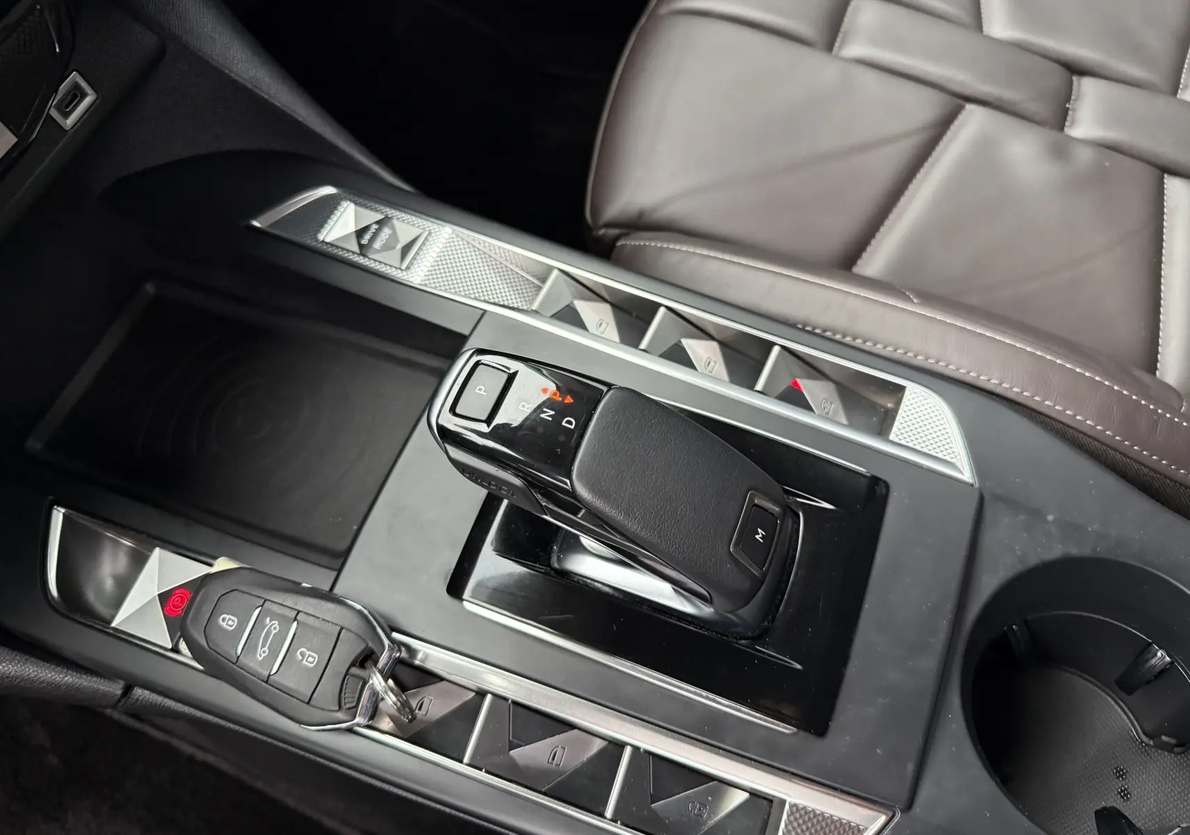 Vue rapprochée de la console centrale noire avec levier de vitesse automatique et clé du DS3 BleuHDi 130 2024.