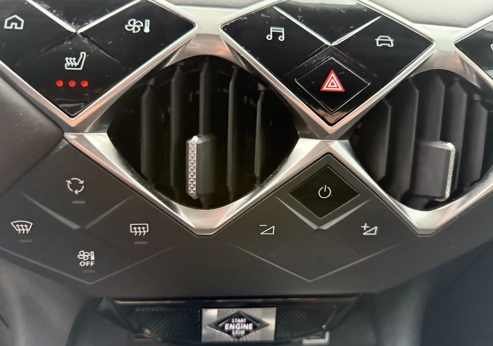 Gros plan sur la console centrale du DS3 2024 noir Perla Nera, montrant les aérateurs et commandes tactiles en losange.